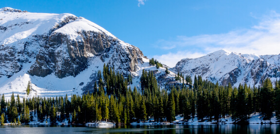 Snow covered mountains with lake in foreground